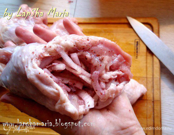 Как следует помнем в руках лук так, чтобы он дал сок. Фаршируем каждое куриное бедро помятым луком. Очень много лука класть не надо, он должен быть как приятное дополнение к курице. 