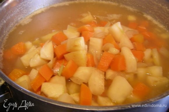 Добавьте овощи в суп, положите зеленый замороженный горошек. Готовьте все вместе на небольшом огне 15 минут. Посолите и поперчите по вкусу, добавьте специи и зелень.
