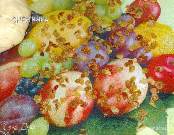 На раскатываемой поверхности распределяем порезанный изюм. 