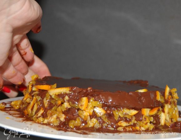 Остывший торт делим на 2 части,смазываем середину апельсиновым джемом,верх и бортики  растопленным  шоколадом.Затем бортики украшаем цукатами.Торт хорош как теплый, так  и охлажденный.