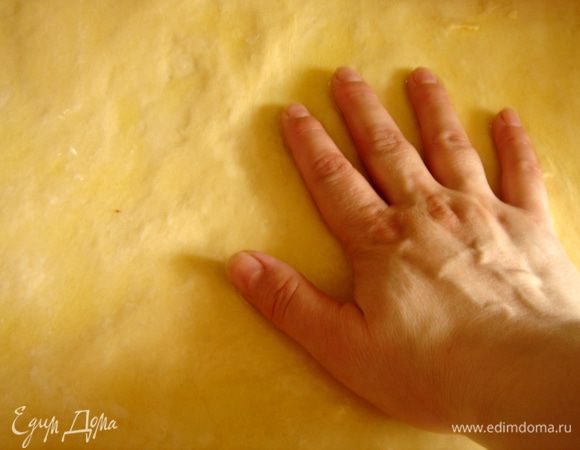 Сливочное масло растопить и обильно смазать им рабочую поверхность.Тесто переложить из миски на смазанный маслом стол.Руками растянуть тесто(оно получается очень мягким и поддатливым и растягивается легко) в большой прямоугольник,постоянно подливая масло на тесто. 