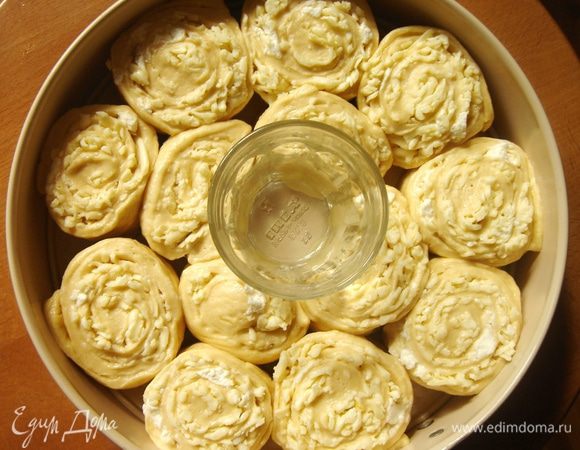 Рулет нарезать на небольшие(ок.5-6 см)кусочки,распиливая тесто,чтобы не нарушались слои.В центр выстеленной пергаментом формы поставить жаропрочный стакан.По кругу разложить кусочки рулета.Убрать пирог в тёплое место на 15-20 минут для расстойки.