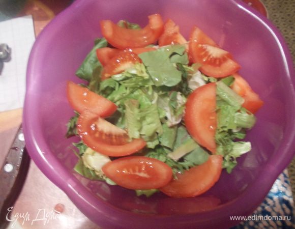 Листья салата промыть, обсушить и выложить в салатницу, добавить нарезанный дольками помидор, сбрызнуть оливковым маслом и соком лимона.