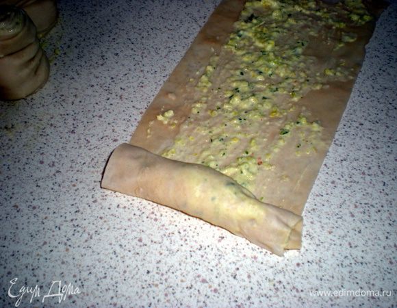Разрезать тесто на полоски шириной 6-8 см.Смазать каждую луковой смесью.Скатать в рулет.
