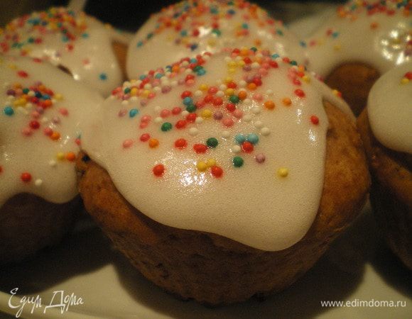 Готовые кексы полить пасхальной глазурью и украсить кондитерской посыпкой.