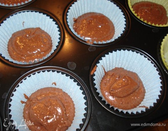 Массу разделить на 2 части.В 1 часть вмешать растопленный белый шоколад,во вторую-темный.
В формочки для маффинов залить массу с темным шоколадом.
