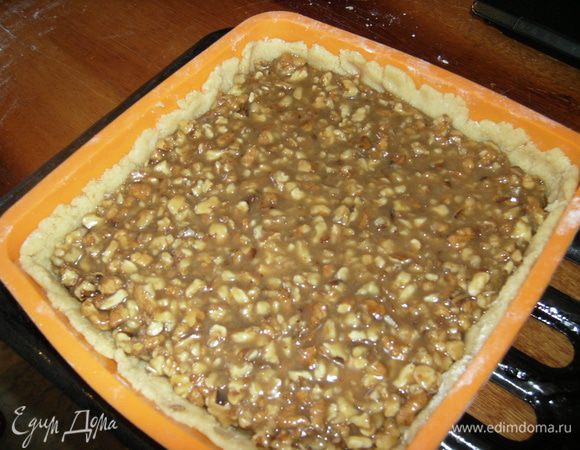 Тесто делим на 2 части (1 часть чуть больше второй). Раскатываем толщиной 3 мм.1 часть кладем в форму на пергамент.
Заливаем орехово-карамельную массу.