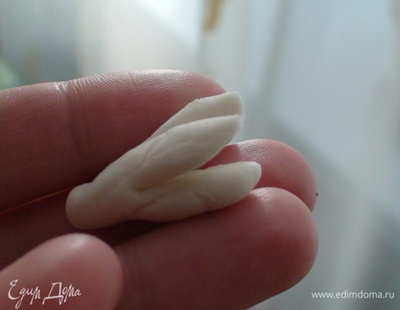 Я решила украсить такими вот весенними цветами.) Делала все быстро и без купленых приспособлений. Итак катаем мастику белую. Делаем небольшие колбаски на одном краю толще. Вот который толще край его и будем резать ножницами крестоподобно.