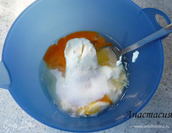 Творог перемешать со сметаной, 2 яйцами, 75г сахара и лимонной цедрой. Добавить ванильный сахар. Разогреть духовку до 175°C.