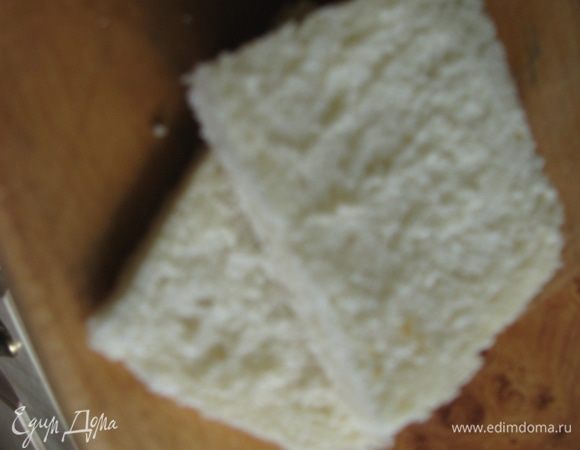 С хлеба срезаем корочку. Смазываем хлеб маслом с одной стороны и кладем маслом вниз на доску. 