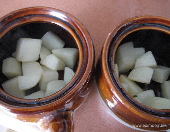 На дно горшочка кладем немного картошки, посыпаем розмарином.