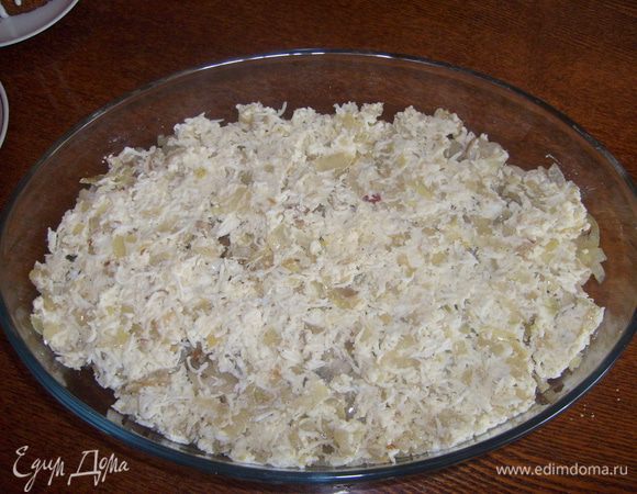 Вторую часть лука смешать с натертыми на мелкой терке яйцами. И выложить слоем на лук.