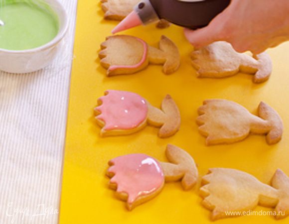 Глазурь одного цвета помещаем в кулинарный мешок, шприц или иное приспособление для декорации изделий. Емкость, с оставшейся пока стоять без дела глазурью, закроем пищевой пленкой, чтобы она не высохла. Декорируем печенье - рисуем контур по области, которую мы планируем залить цветом, затем аккуратно покрыаем глазурью всю площадь внутри контура. Слой глазури должен быть тонким, т.к. при застывании она становится довольно твоердой, толстый слой глазури сделяет печенье жестким.