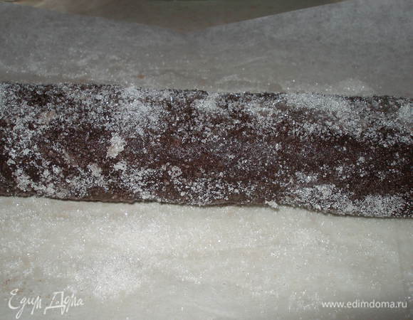 Снять пергамент и прокачать тесто по рассыпанному сахару так, чтобы сахар облепил его со всех сторон.