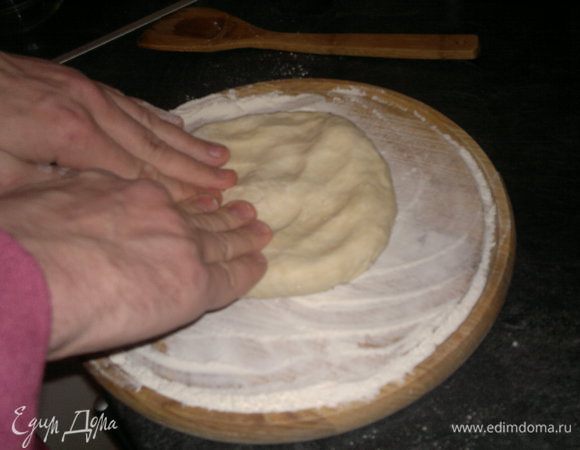 Достаем наше остывшее тесто и начинаем его.... даже не скажу раскатывать, скорее разминать руками, примерно вот так: