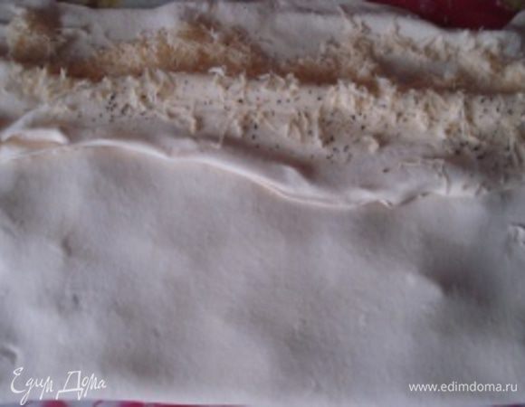 Накрыть половиной теста с добавками сырную половину так, чтобы края совпадали. Соединить края теста и снова раскатать тесто до первоначального размера.