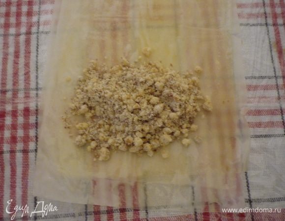 Выложить друг на друга 3 полоски теста, каждую промазывая растопленным маслом. На самый краешек выкладываем начинку.