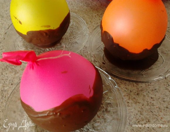 надуть 3 не больших воздушных шарика и завязать их ниткой,обработать сначала спиртом,а потом уксусом.Дать высохнуть.На блюдце налить немного шоколада,для того чтобы шарик устойчиво стоял.В миски где растапливали шоколад окунуть шарик и обмазать его