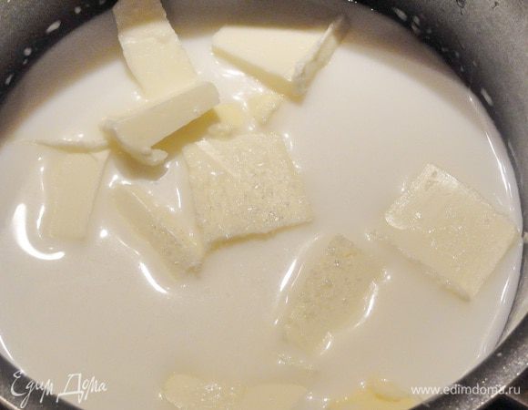  В кастрюльку выливаем молоко и воду. К ним добавляем масло кусочками и сахар. 