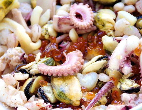 Отварить морской коктейль. Откинуть на дуршлаг и дать морепродуктам немного остыть. Оливковое масло смешать с соком половины лимона. В салатнике соединить морепродукты с заправкой.