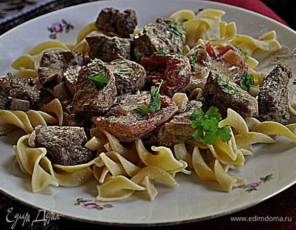 Снимаем сковороду с огня,добавляем сметану и все перемешиваем.Подаем свинину паприкаш поверх яичной лапши,украсив петрушкой.