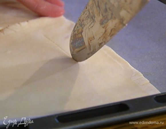 Противень выстелить бумагой для выпечки, выложить тесто и на каждом пласте, отступая на 2 см от края, ножом прочертить квадрат, не прорезая тесто до конца, чтобы получились бортики.