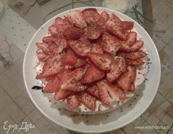 Торт убрать в холодильник на всю ночь, до полного застывания.
На следующий день бортик с формы снять, осторожно снять пергамент с боков, торт осторожно переложить на тарелку.
Готовый торт украсить порезанной клубникой и тертым шоколадом.