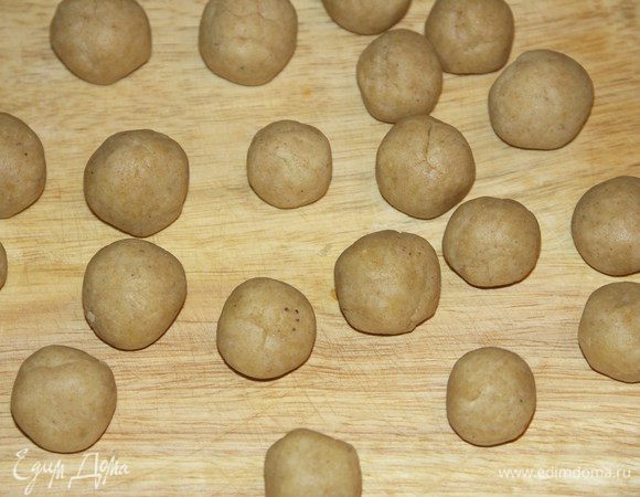 Разделить тесто на 2 половинки.Одну снова завернуть в плёнку и убрать в холод.И второй скатать 20 шариков...