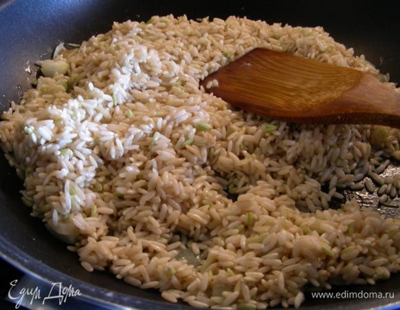 Затем всыпаем рис и обжариваем его пару минут на среднем огне, чтобы он пропитался маслом.
