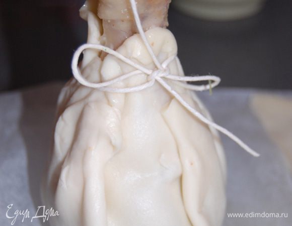 Затем на шпинат поставьте слегка остывшую голень,соберите края теста,формируя лукошко и завяжите шпагатом бантик,но не сильно надавливая на тесто. 