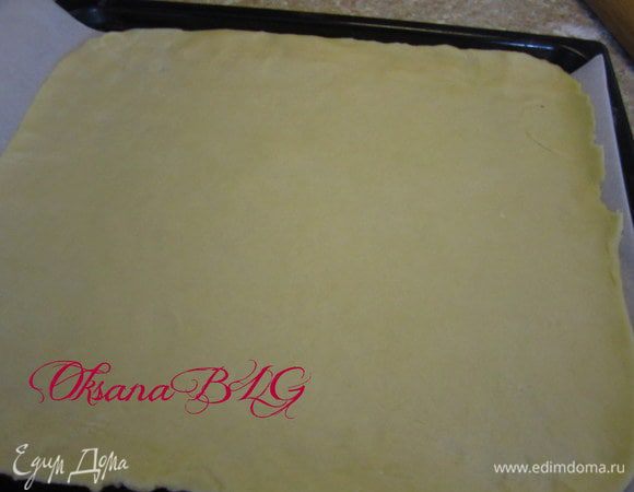 Противень застелить пергаментной бумагой. тесто разделить на 2 части 1 больше вторую меньше. Большую часть раскатать и выложить на противень.