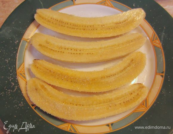 Выложите аккуратно бананы на тарелку и посыпьте с двух сторон сахаром. Подождите пару минут, чтобы сахар "прилип" к кусочкам банана.