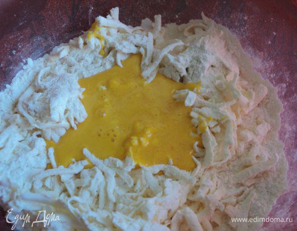 В муку натереть на терке охлажденное масло, добавить взбитые с сахаром желтки и быстро замесить тесто.