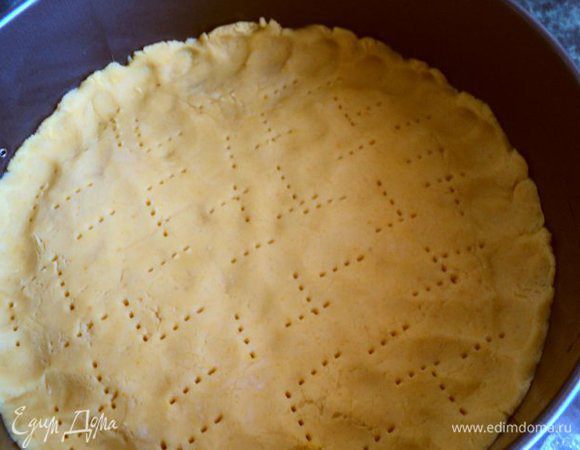 На дно разъемной формы положить бумагу для выпечки, смазать маслом и выложить тесто, разровнять руками, сделав небольшие бортики по краю, наколоть вилкой.