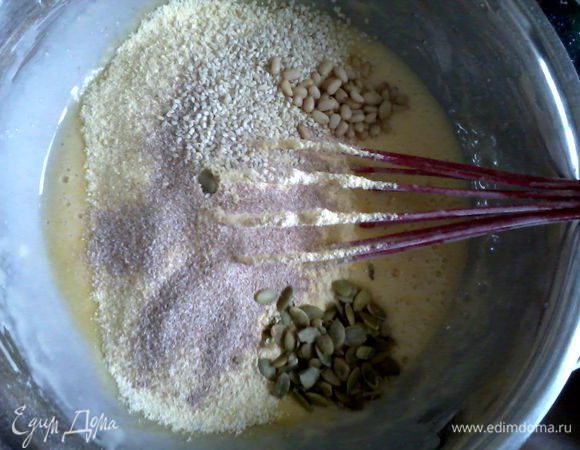 Яйца взбить с сахаром венчиком. Добавить йогурт, масло, перемешать. Добавляем просеянную пшеничную и кукурузную муку с разрыхлителем, соль, вымешиваем. Засыпаем орешки, семечки, отруби, все хорошенько перемешать.