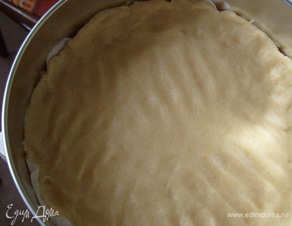 Руками вымесить тесто. Поместить тесто в разъемную форму, дно которой выложено смазанной растительным маслом пекарской бумагой. (Форму лучше брать диаметром 23-25 см. разъемную, так как начинка очень нежная и из неразъемной формы пирог будет тяжело достать).
Аккуратно руками разровнять тесто.