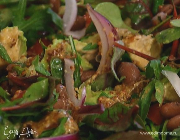 Выложить на блюдо листья салата, помидоры, авокадо, петрушку, маринованный лук и фасоль, полить 2/3 заправки и слегка перемешать.