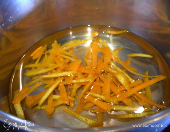 Берем небольшую кастрюльку, кладем в нее нашу цедру, заливаем холодной водой (немного выше самой цедры). Доводим до кипения, воду сливаем. Повторяем еще 2 раза. Это нужно, чтобы убрать горечь. Затем добавляем 20 г сахара, опять заливаем холодной водой и готовим на небольшом огне минут 20. 