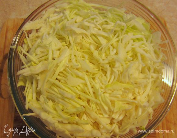 Поставьте чайник с полутора литрами воды на огонь и сделайте кипяток. В это время нарежьте капусту соломкой. Если соломка получается слишком длинной - разрежьте ее на части.