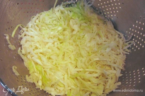 Через 10 минут, после заливки кипятком капусты, выложите капусту в дуршлаг и отожмите капусту.
