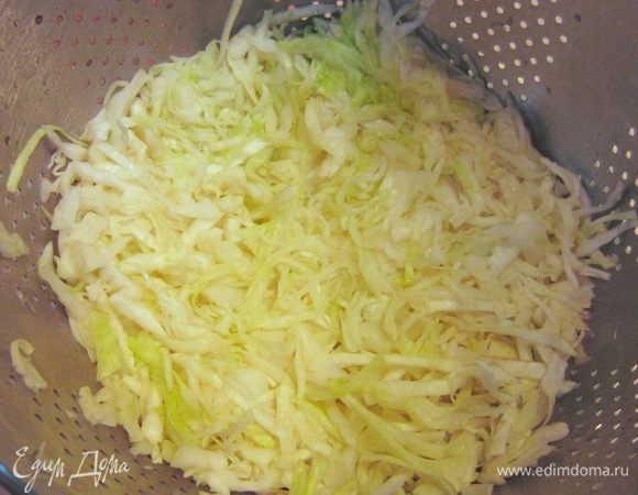 Через 10 минут, после заливки кипятком капусты, выложите капусту в дуршлаг и отожмите капусту.