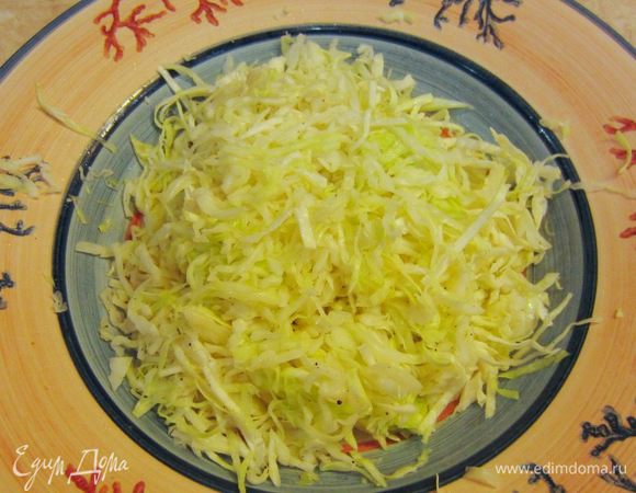 Выложите капусту в большое подогретое блюдо. Посолите и поперчите, перемешайте капусту.