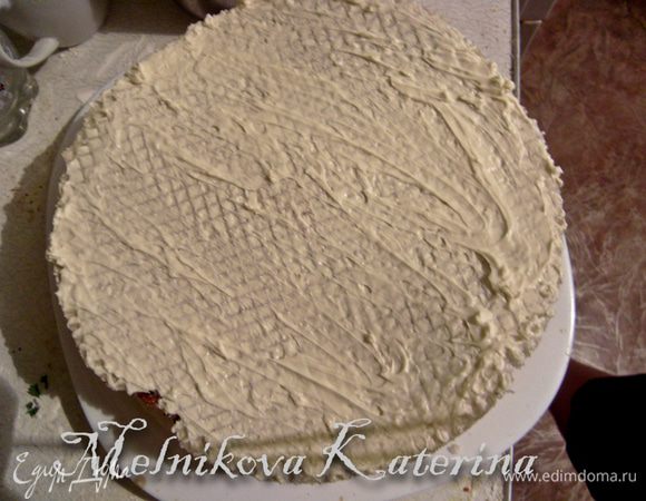 Поверх шоколада выкладываем чистый вафельный корж. Смазываем его кремом так, чтобы заполнить все ячейки. 