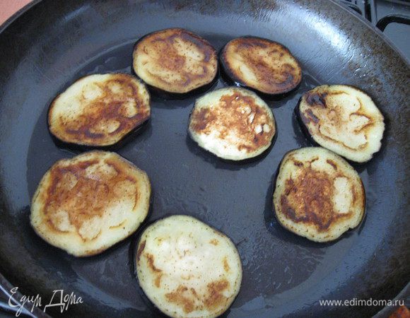 Баклажаны нарезать кружками, посолить, оставить на 30 минут. Промыть водой, обсушить бумажным полотенцем. Сбрызнуть оливковым маслом и обжарить на гриле или сковороде. Выложить на салфетку, чтобы впиталось лишнее масло.