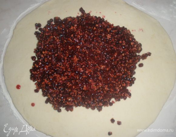 Смешать орехи с ягодой. Тесто раскатать в круг толщиной около 8 мм. Выложить в центр начинку, от краев останется примерно по 8 см.