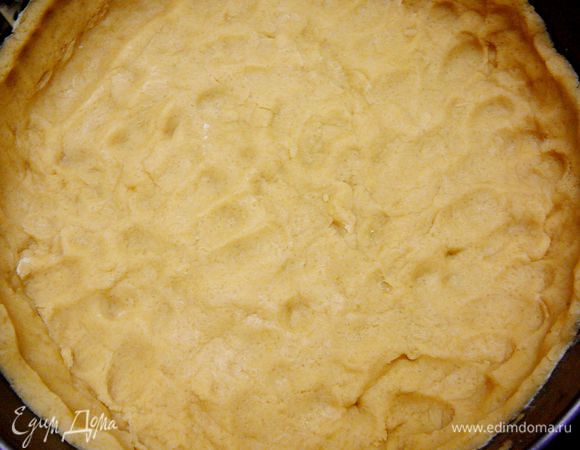 Тесто раскатать диаметром большим чем форма.Уложить в форму,сформировать бока высотой примерно 4-5см.Наколоть тесто вилкой.