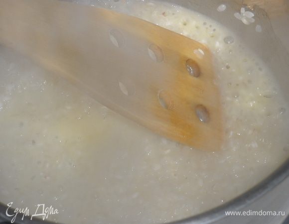 Масло разогреть в сотейнике. Всыпать туда промытый рис и, помешивая, обжарить его, пока рис не покроется тонкой блестящей корочкой. Затем влить кипящее молоко, добавить щепотку соли и натертую цедру лимона.