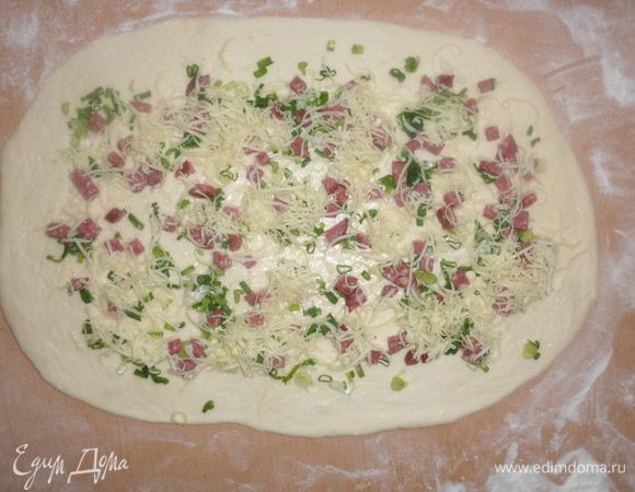 Распределяем по пласту теста зеленый лук, колбасу и сыр.