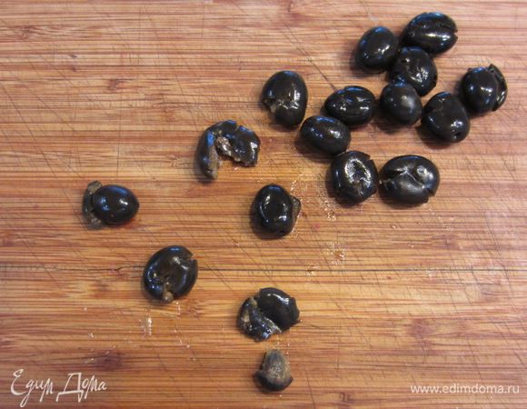 Достаньте оливки. Надавите на оливки пальцем или плоской стороной ножа, чтобы было легко достать косточки. Выберите все косточки. Помните, что оливки с косточками значительно вкуснее оливок без косточек.