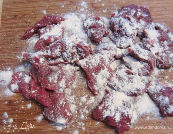 Теперь необходимо посолить, поперчить и обсыпать мукой мясо. Выложите мясо на сухую доску. Посыпьте солью и перцем. Посыпьте мукой.